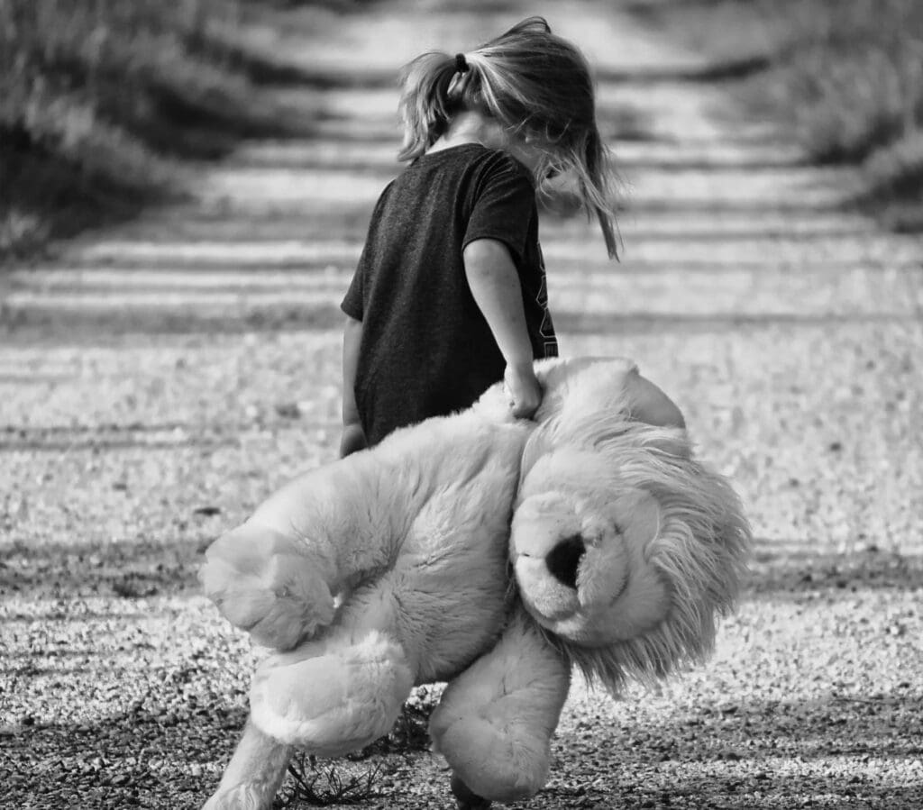 A little girl holding onto a teddy bear